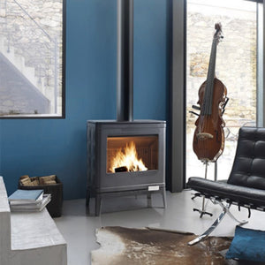 Modern living room with a lit wood stove, black chair, and violin in the background.